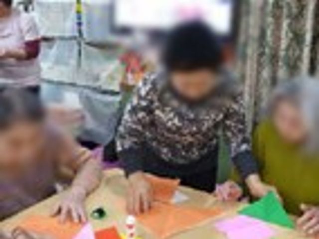 紙工作をする様子 多目的室 レクリエーションの一環として、利用者さん達が楽しんで紙工作に取り組んでいます。室内は和やかな雰囲気です。