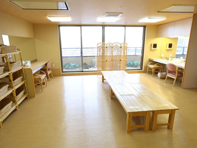 広々とした明るい空間 脱衣所 窓から自然光が差し込む清潔感のあふれるスペースです。木製のテーブルや椅子も配置され、ここで様々なアクティビティが楽しめます。