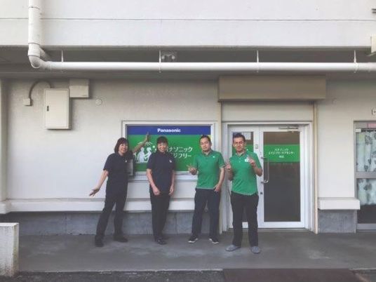 スタッフが並ぶ建物外観  