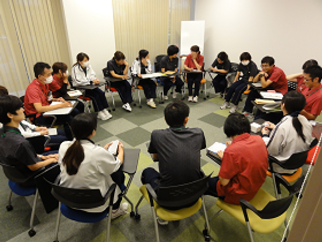 円形に囲む多目的室 多目的室   椅子を円形に並べた明るい多目的室です。参加者が向かい合って話し合える、落ち着いた場になっています。