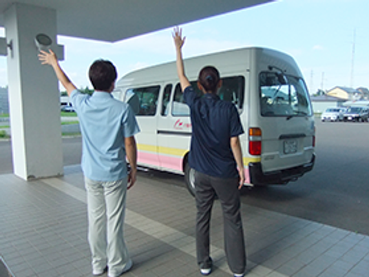 送迎を見送る職員の外観  
