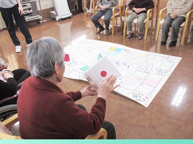 楽しい活動をする室内 休憩室 椅子に座った方々が、ゲームに参加し交流を楽しんでいます。リラックスした雰囲気が特徴です。