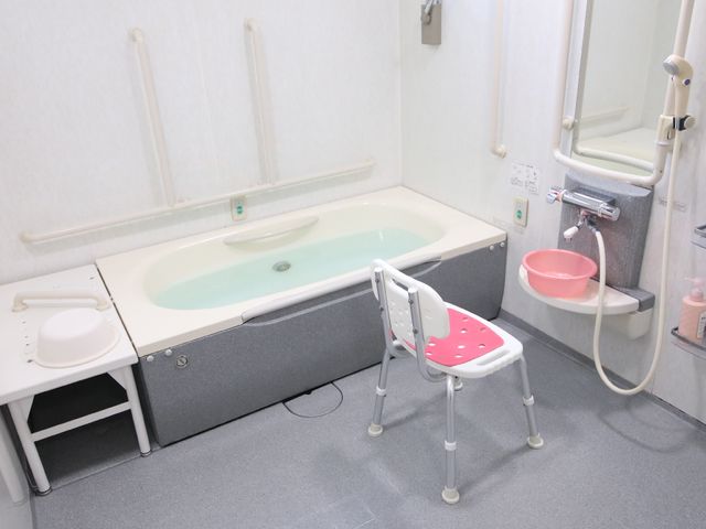 バリアフリー対応浴室 浴室 安全な手すりが備えられた明るい浴室です。水周りの配慮により、利用者の快適な入浴を支援しています。