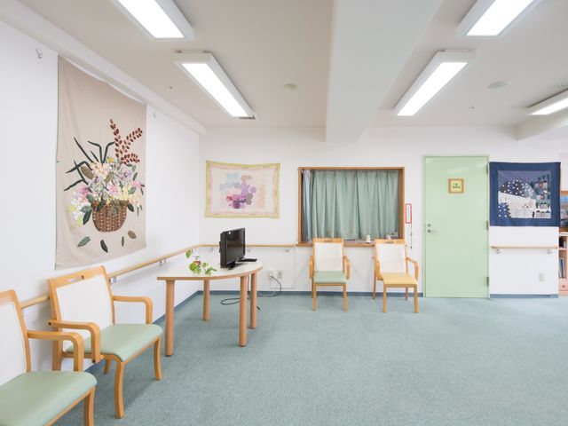 和やかな休憩室 休憩スペース 明るく清潔な休憩スペースがあり、壁には風情あるタペストリーが飾られています。ゆったりとした椅子も用意され、静かに過ごせる環境です。