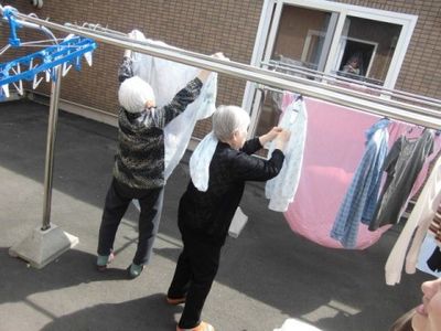 洗濯物を干す高齢者二人