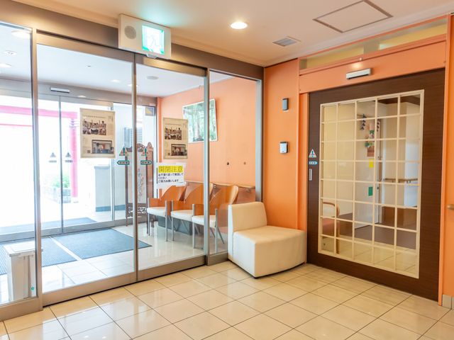 開放的な入口のエントランス エントランス 広々としたエントランスには、自然光が差し込む座席スペースがあります。温かみのある雰囲気です。