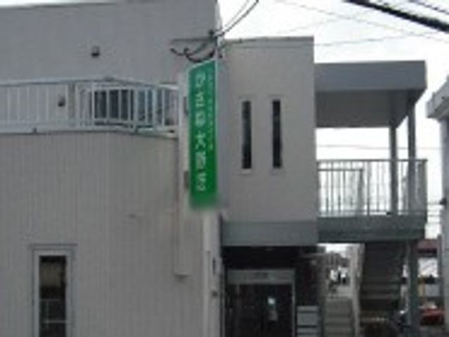 緑の看板が目立つ建物外観