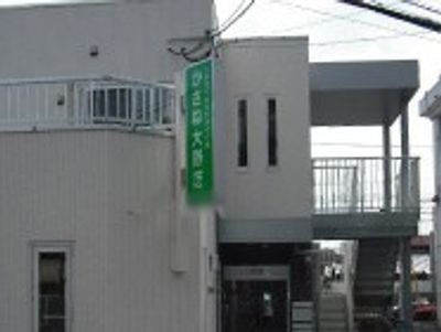 緑の看板が目立つ建物外観