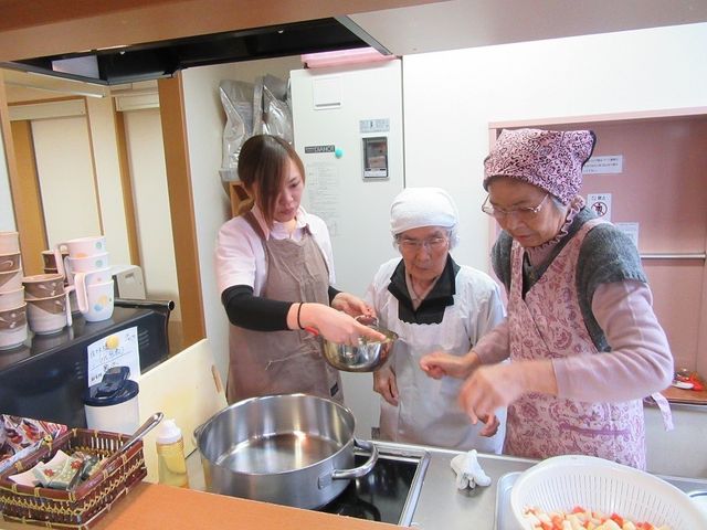 調理活動する人々 キッチン 心温まる共同調理の場を提供し、笑顔で協力しあう様子が伝わります。