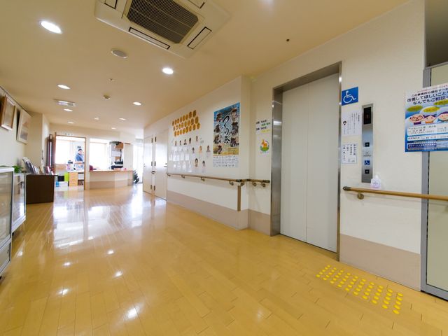 廊下の明るい様子 廊下  清潔感があり、広々とした通路は来訪者を温かく迎えてくれます。壁面の掲示物からは日々の生活情報を得られます。