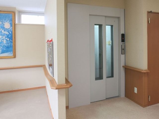 エレベーターと廊下の角 エレベーター 手すりが設けられた安全な移動空間です。エレベーターの利用もスムーズで、待ち時間を感じさせない設計になっています。