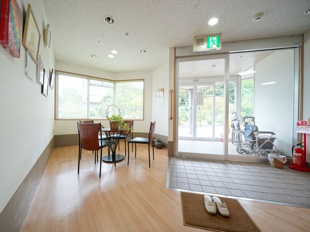 明るい中庭への出入口 玄関 ゆったりとしたエントランスには、天井からの自然光が差し込み、外への出入りも心地よい環境です。過ごしやすい空間で、訪問者の方々をお迎えいたします。