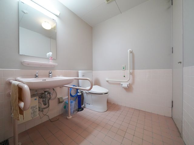 手すり付き清潔なトイレ トイレ バリアフリー設計の清潔で広々としたトイレが完備されており、日々の快適な支援が行えます。手すりや安全ボタンが整っていて、利用者の安心に配慮された環境です。