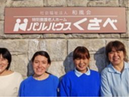 笑顔のスタッフと看板