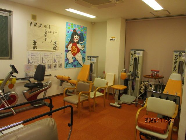 機能訓練室の器具と掲示物 多種多様な器具が整えられた訓練室です。壁には運動指導のポスターが掲げられ、利用者の健康維持をサポートしています。