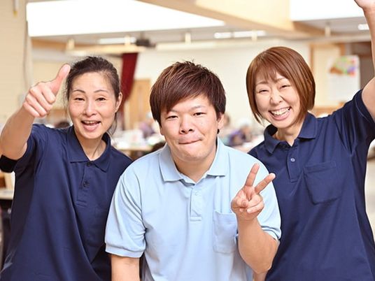 笑顔の職員が並ぶ食堂  