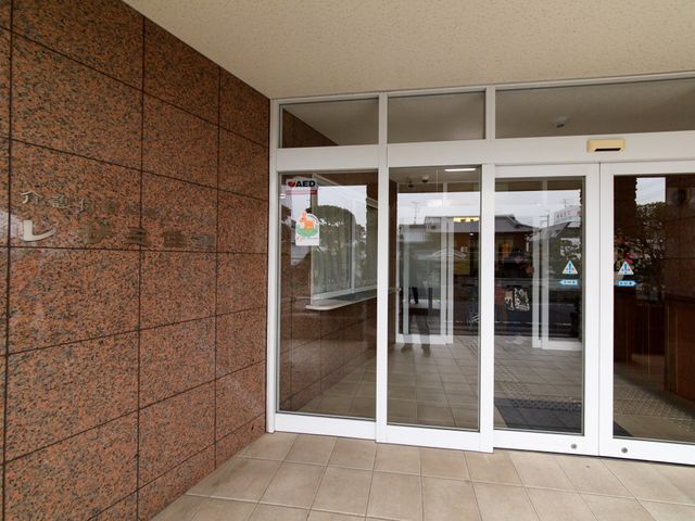 エントランスの自動扉と掲示 玄関 ガラス張りで明るい入り口には自動的に開閉する扉が備わっており、安全と利便性を重視した設計がなされています。