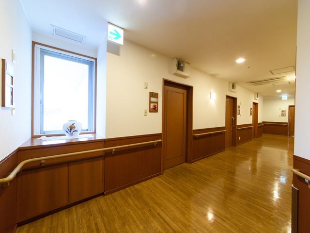 清潔感のある明るい廊下 通路 光が差し込む、ゆったりとした廊下は、安全な手すりが備え付けられ、快適な通行が可能です。
