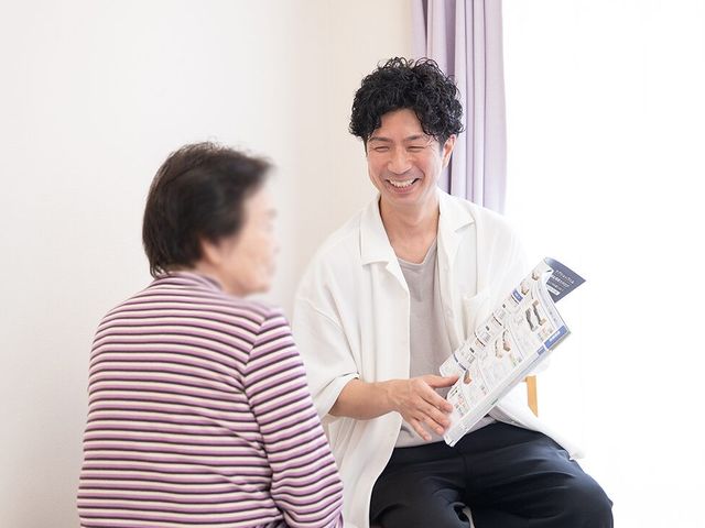笑顔のスタッフと利用者の居室 居室 温かい雰囲気の中で、スタッフが利用者と親身にコミュニケーションをとっています。
