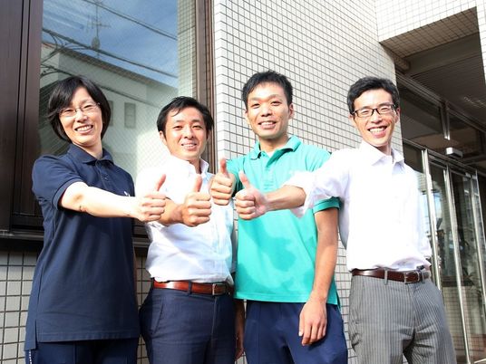 笑顔の職員が並ぶ外観  