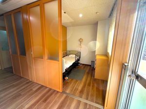 居室の木目床とベッド  