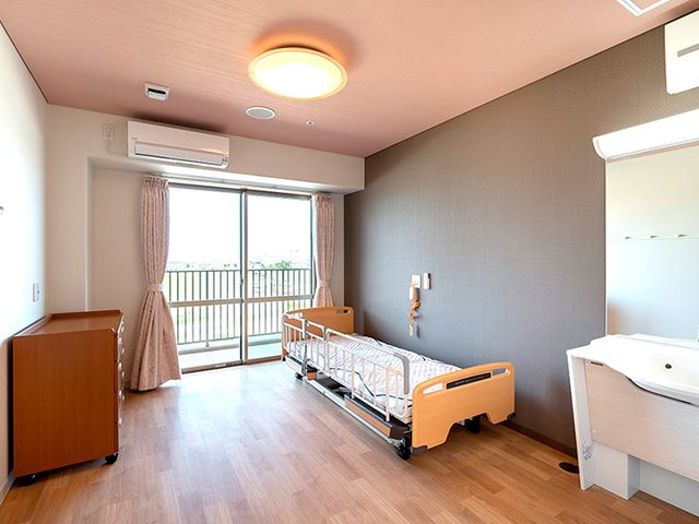 明るい部屋の居室 居室 自然光が差し込む居室は、広々としたスペースで快適に過ごせます。ベッドサイドには手すりも配備されています。
