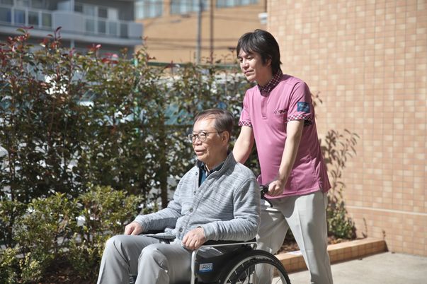 車椅子の男性と介護士の庭