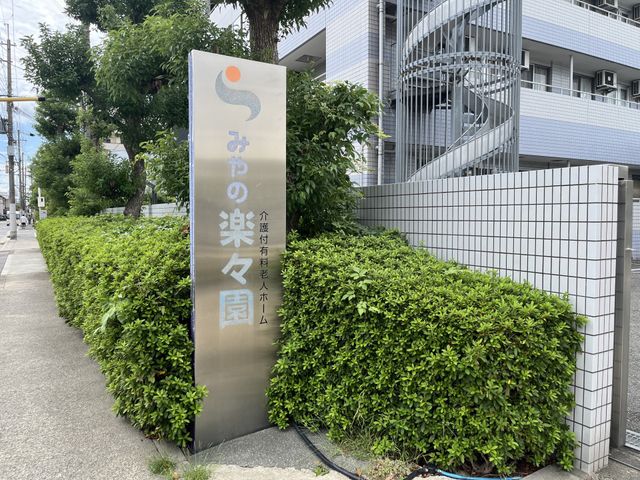 看板の前の緑あふれる場所 看板 清潔感のある外観と和やかな雰囲気の看板が、温かな迎えを示しています。緑も多く、落ち着いた環境です。