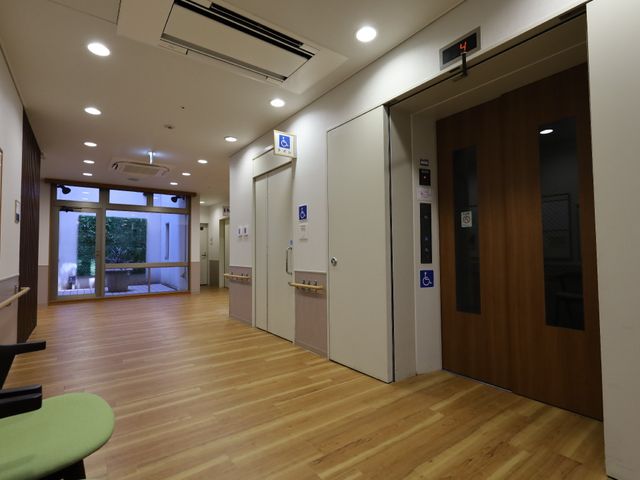 清潔感のある廊下の一角 エレベーター 落ち着いた色合いの壁と床が、快適な移動空間を提供しています。明るく開放的な通路が特徴です。