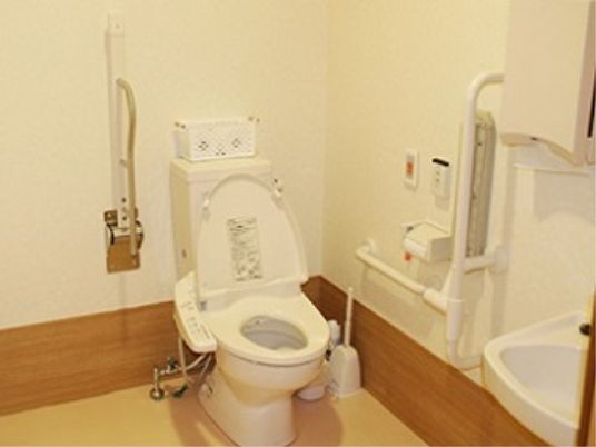 トイレの周辺には手すりが付いており、立ち上がる支えとなる。壁には非常時をスタッフに知らせるボタンもついており、安心である。