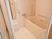 白で統一された爽やかな浴室にはバスタブとシャワー、鏡が設置されている。また、手すりが各所に取りつけられている。