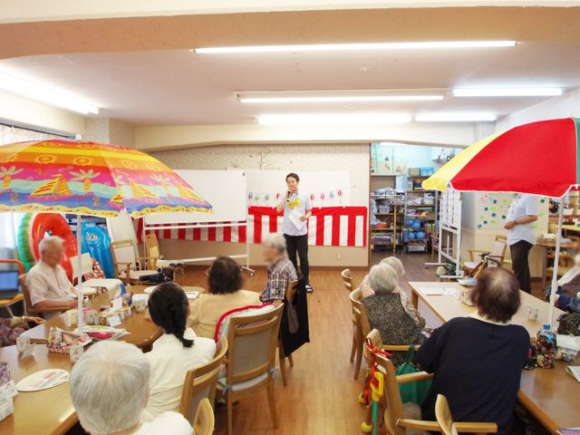 カラフルなイベント 多目的室 陽気な雰囲気の中で、利用者の方が一緒に楽しく活動されています。スタッフのサポートがあります。