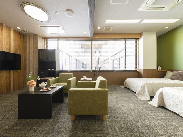 理美容室での施術風景 ファミリールーム 明るく清潔な理美容室で、笑顔のスタッフが丁寧な対応をしており、利用者の方に安心感を提供しています。