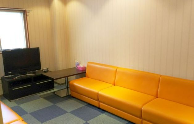 オレンジのソファとテレビの居室