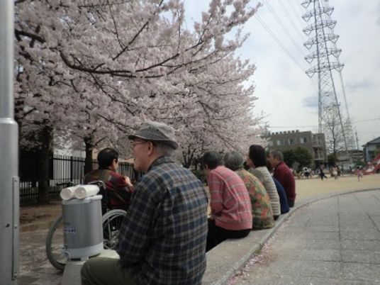 桜並木と談笑する人々