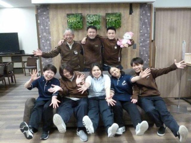 笑顔のスタッフ集合ロビー ロビー   笑顔のスタッフの皆さんが集まり、親しみやすい雰囲気が伝わります。明るい空間で、働く人のチームワークを感じられます。