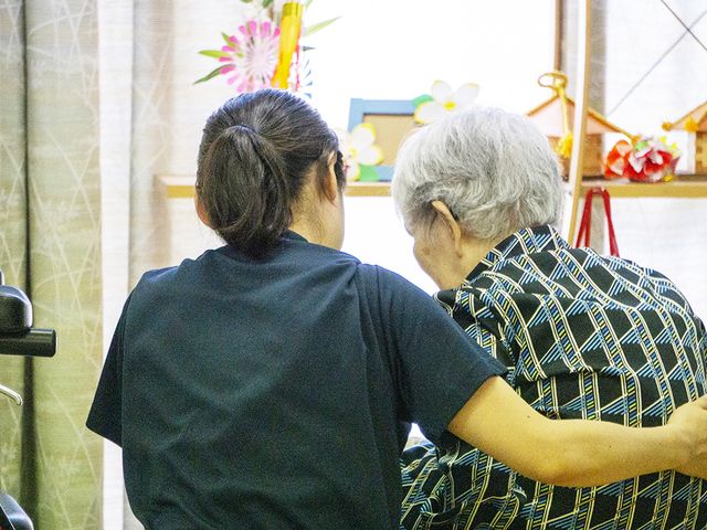 介護スタッフと利用者の様子 優しい支援のもと、利用者が日常動作の訓練を行っています。心温まる接し方に、就業意欲が湧く場面です。