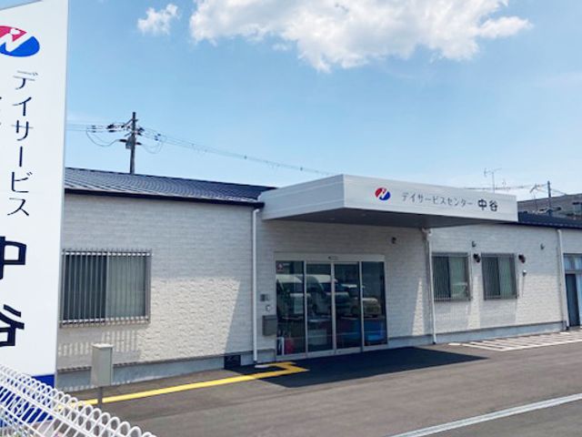 看板 外観 広い駐車スペースと明るい外観が特徴の建物です。入口はガラス扉で、アクセスが便利です。