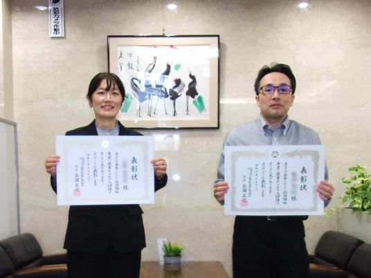 表彰状を持つ職員  