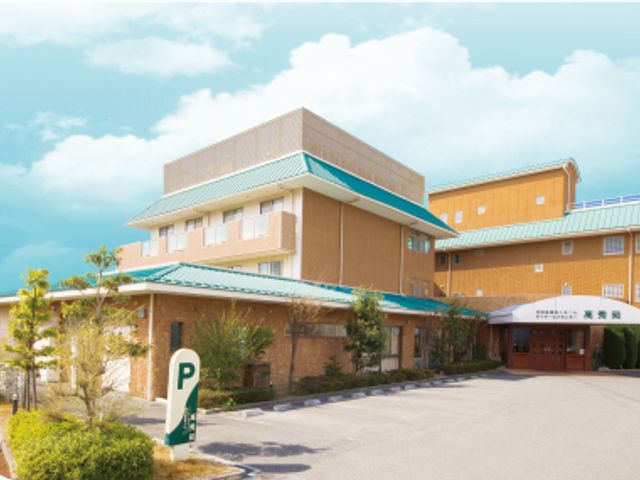 青い屋根の建物外観 外観 広い駐車場と青い屋根が印象的な建物です。施設の入り口には清潔感があります。