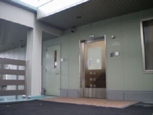 エントランスの明るい外観 玄関 広々とした入口はバリアフリー設計で、明るい雰囲気が迎え入れてくれます。快適で安心の環境をお求めの方に適しています。