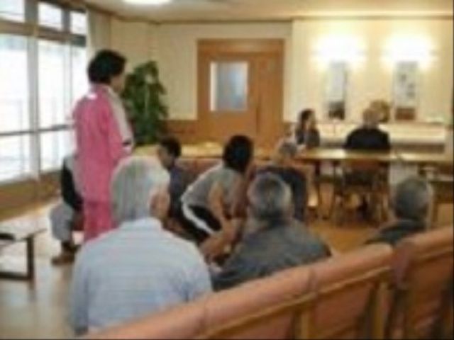 和やかな居室の風景 レクリエーション 明るく広々とした居室で、利用者の方々が和気あいあいと過ごしています。職員の方も親しみやすい姿勢で対応しており、心地良いコミュニケーションが育まれています。