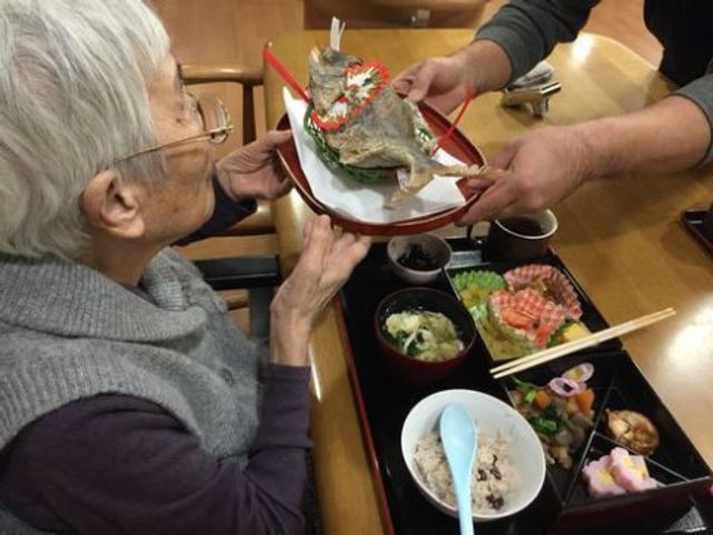 食事の時間の風景 食事 手渡される特別な料理に目を輝かせる方々。栄養満点で彩り豊かな食事が日々の健康を支えます。