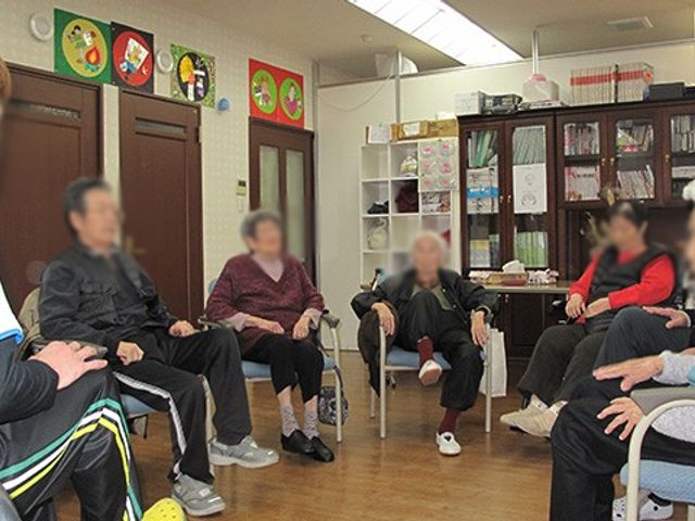 活動を楽しむ様子の部屋 多目的室 広々とした部屋で、利用者同士が楽しく交流しながら活動に参加しています。明るい雰囲気です。
