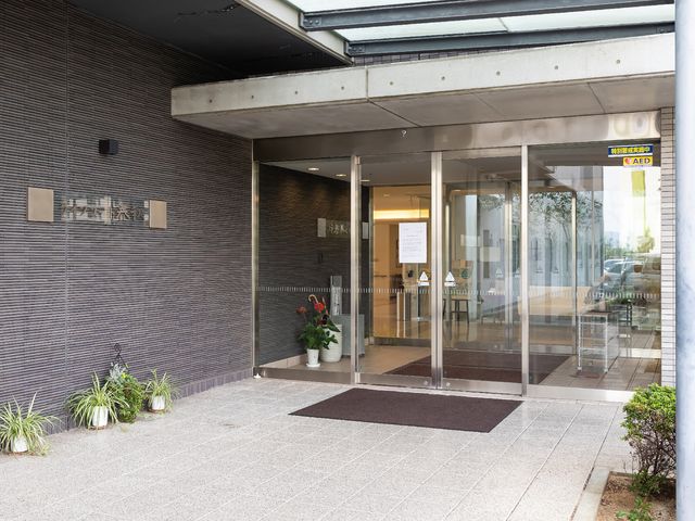 清潔感のある施設エントランス 玄関 ゆったりとしたエントランスは明るく、心地よい第一歩をお迎えします。植物が彩る玄関は、訪れる方々に安らぎを提供しています。