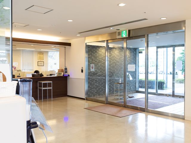 入り口とフロントの風景 玄関 ゆとりあるエントランスは、来訪者を明るく迎え入れます。受付も整っており、日々の業務が円滑に進む環境です。