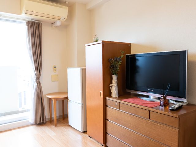 居室内の家具とテレビ 居室 陽光が差し込む居室は、居心地の良い空間を演出しており、家具が整然と配置されていますので、快適にお過ごしいただけるでしょう。