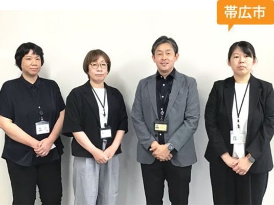 スタッフ4人が並ぶ様子  