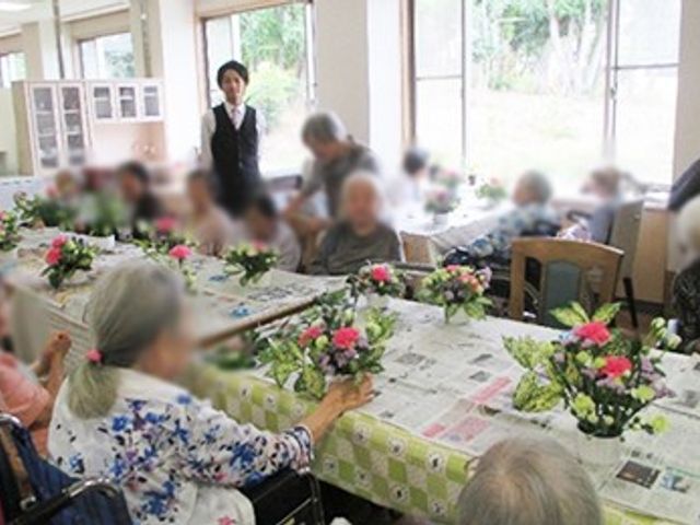 明るいダイニングルーム ダイニングルーム 大きな窓から自然光が差し込み、花が並ぶテーブルで和やかに歓談中の空間です。