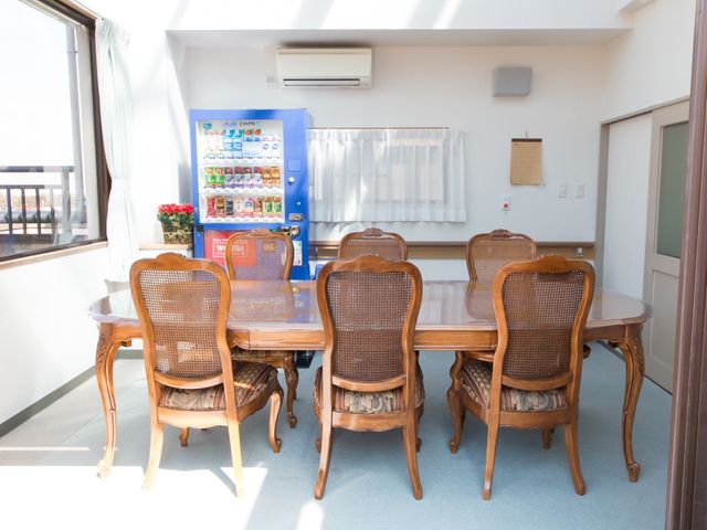 テラス席のある休憩室 サンルーム ゆったりした机と椅子の休憩室で、自動販売機の飲み物と共に心地良いひと時を過ごせます。明るく開放的な空間は、日常のリフレッシュに最適です。
